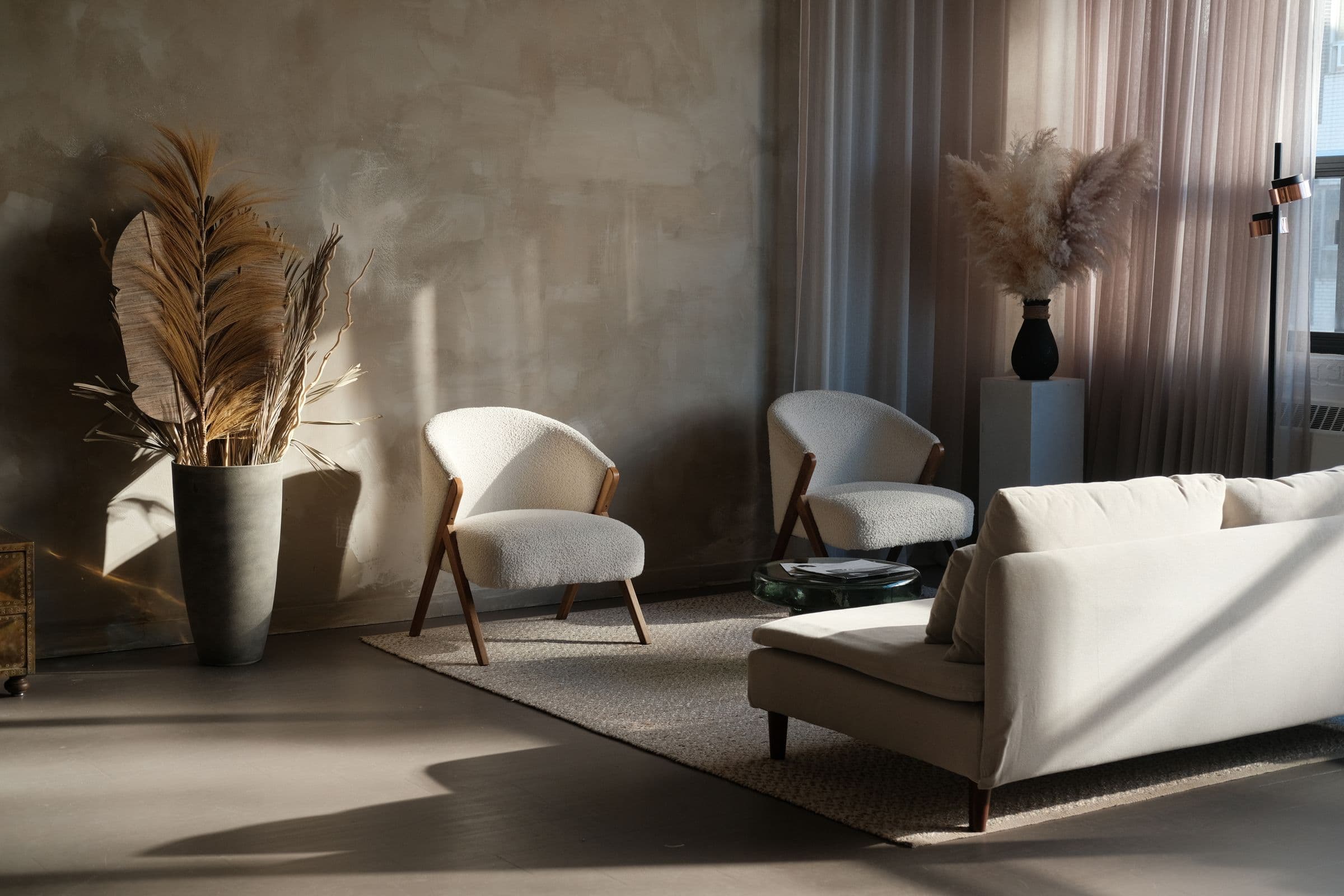 Moody living room with a textured plaster wall, pampas grass and low natural light